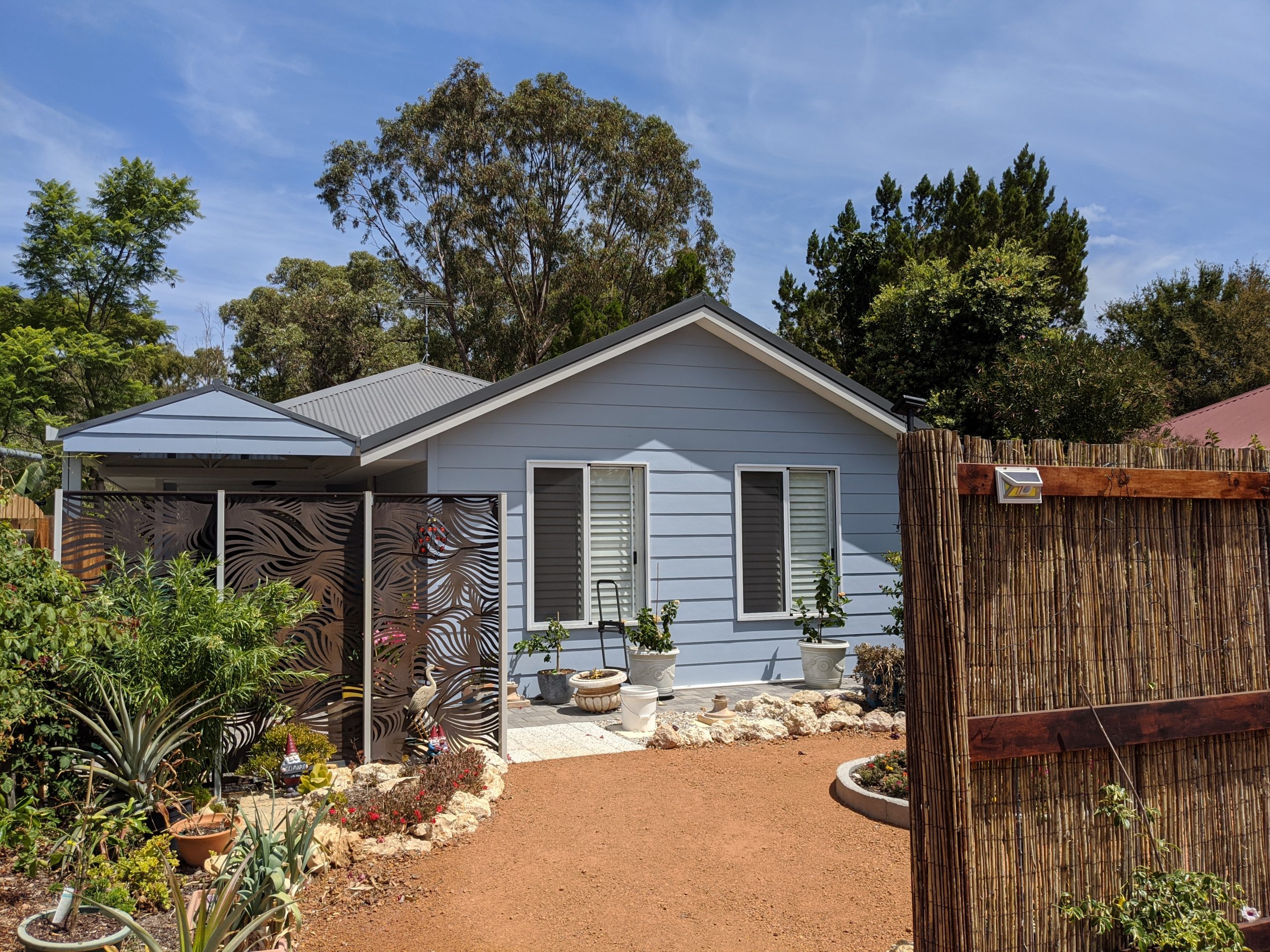 Picture of a granny flat on a residential house block surrounded by gardens. Granny Flat was built by Just Ask Just Builders in Mandurah Western Australia.